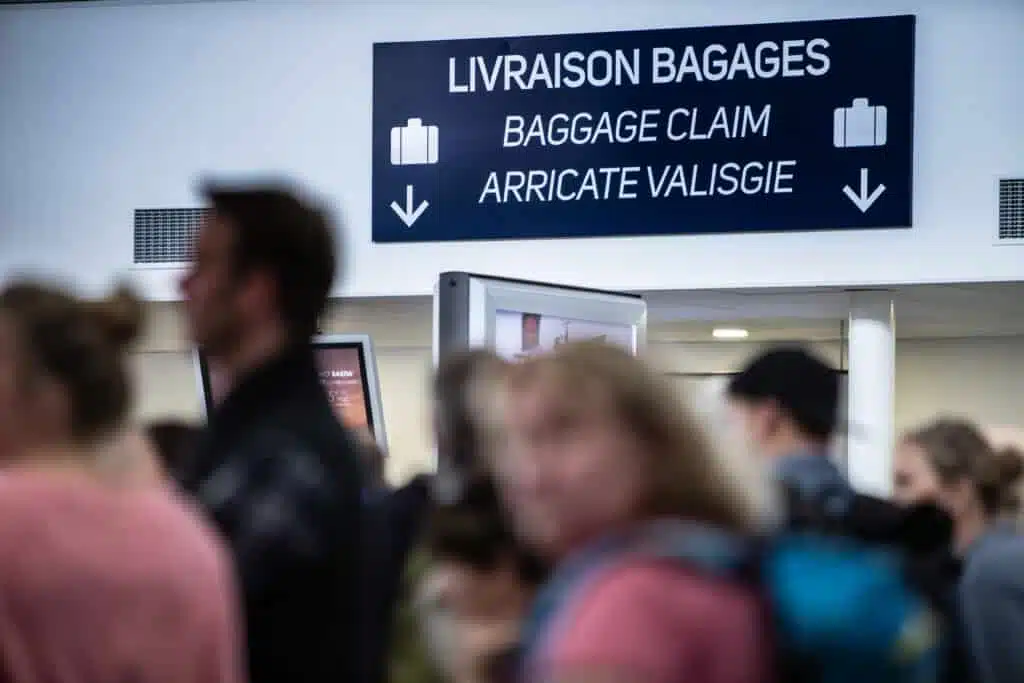 Panneau livraison bagage avec des gens devant