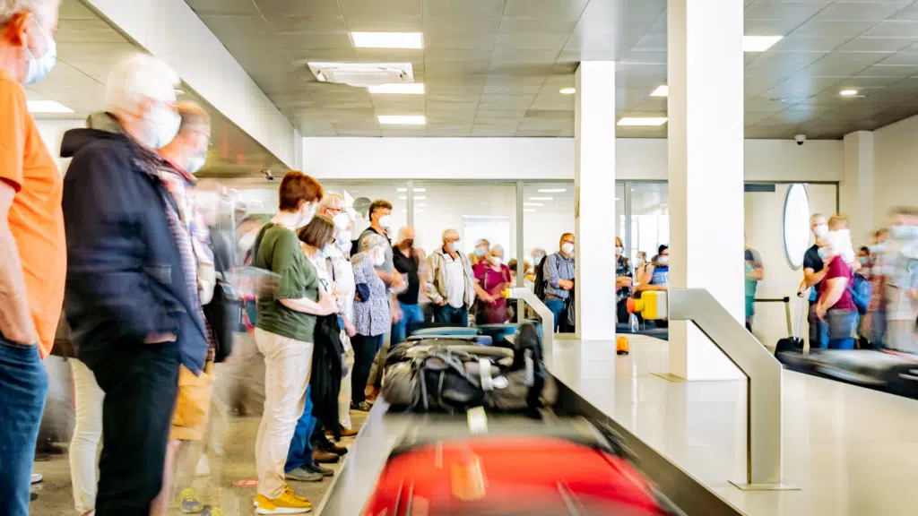 Les voyageurs attendant leurs bagages devant le tapis