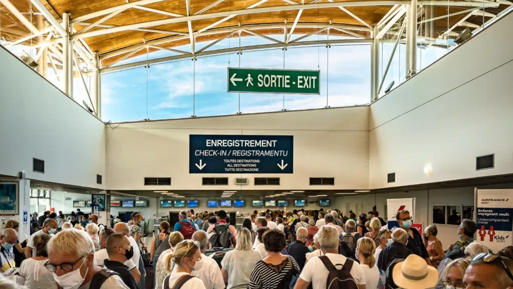 Photo montrant le panneau sortie dans l'aérogare bondée de monde